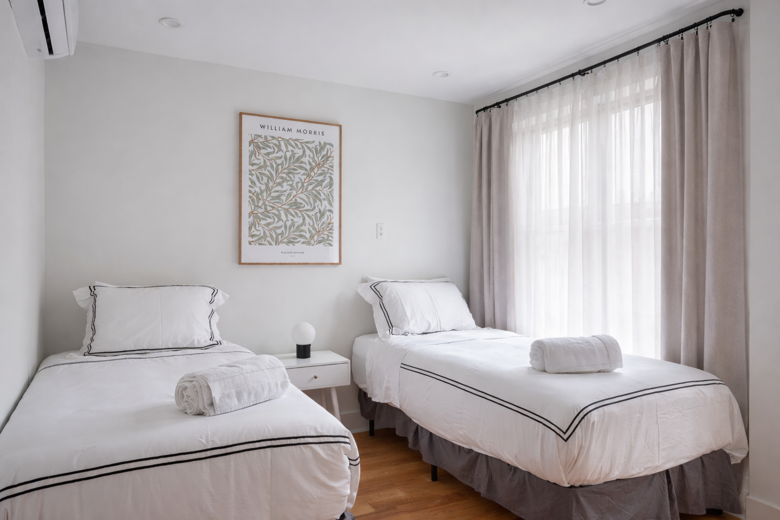 Twin bedroom with two beds and a framed William Morris print